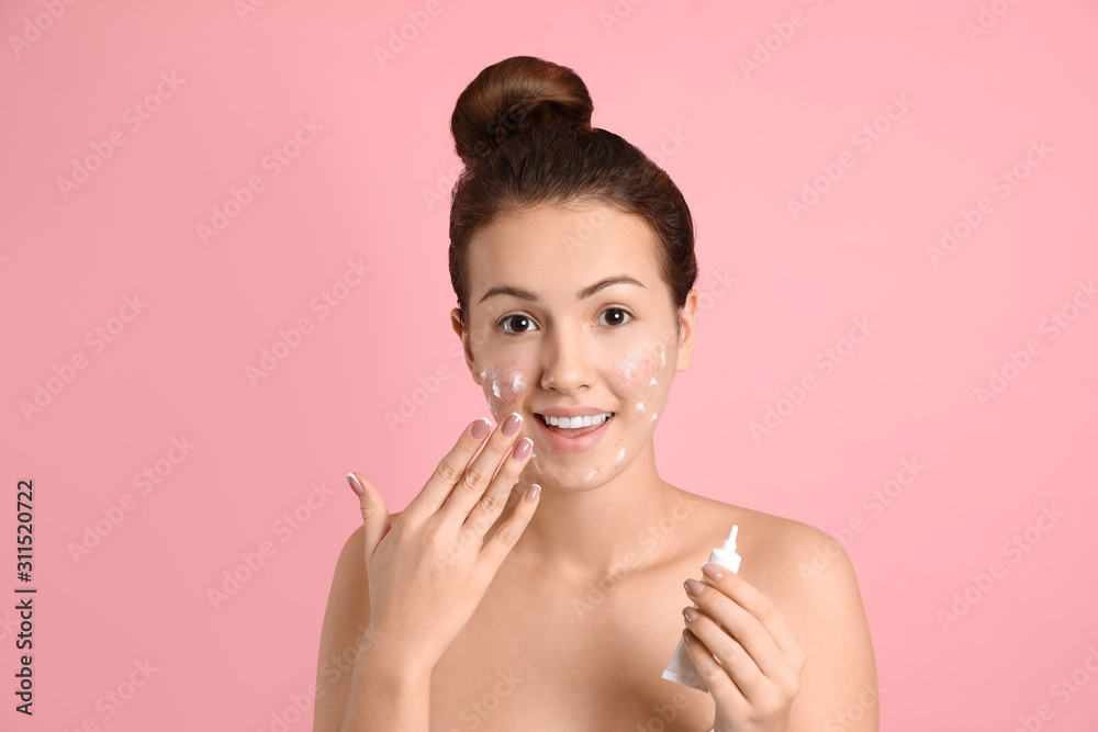 Teen girl with acne problem applying cream on light pink background Stock  Photo | Adobe Stock