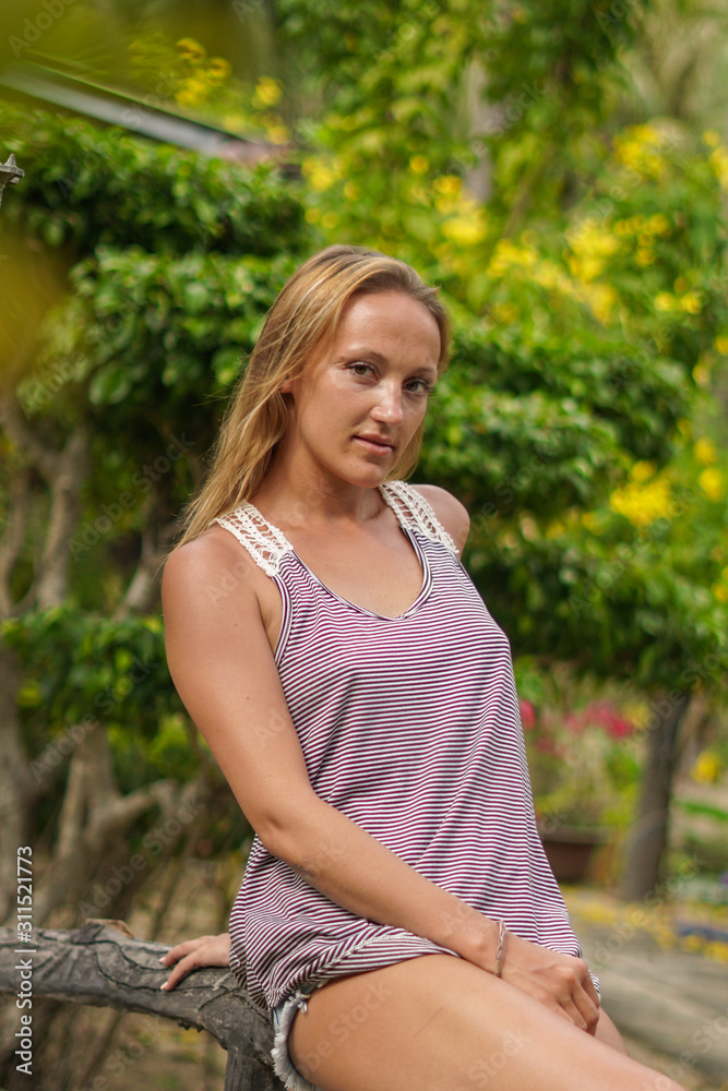 The girl posing in the tropical garden with palms The girl posing in the tropical garden with palms