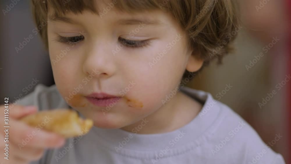 Cute Little Caucasian Boy Eating Pizza. Hungry Child Bites Pizza. Small Child in a Fast Food Cafe Eats. Close Up Portrait of a Kid Eating Lunch. Face Young Little Boy Closeup.Time Lapse. Cute Little Caucasian Boy Eating Pizza. Hungry Child Bites Pizza. Small Child in a Fast Food Cafe Eats. Close Up Portrait of a Kid Eating Lunch. Face Young Little Boy Closeup.Time Lapse.