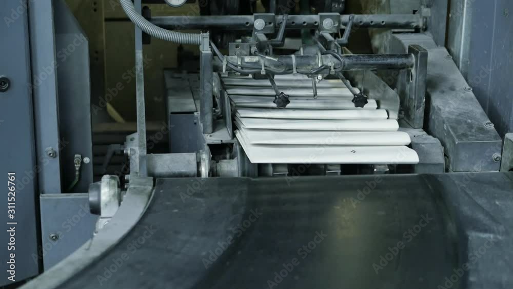 Empty blank white newspaper at the conveyor of a printing factory Empty blank white newspaper at the conveyor of a printing factory