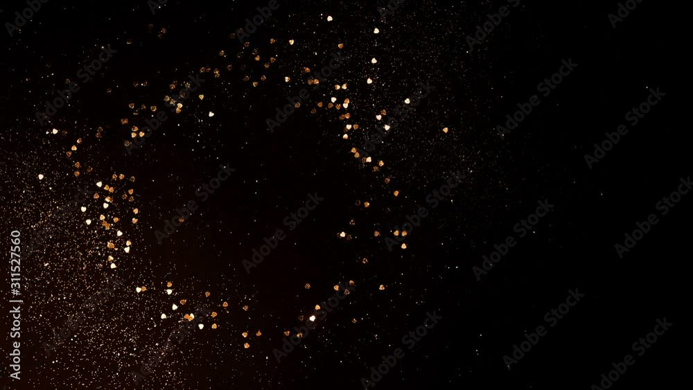 Creative concept of Christmas festive and New Year background, flickers and glitters. Golden glitter sparkles and hearts on a black background. Copy space Creative concept of Christmas festive and New Year background, flickers and glitters. Golden glitter sparkles and hearts on a black background. Copy space