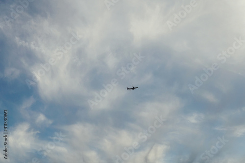 a passenger plane flying in the sky over the sea v