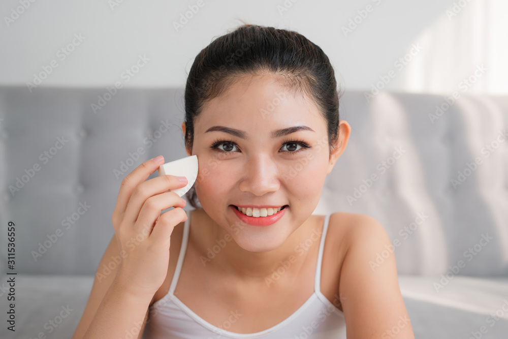Potrait of young Asian woman using sponge blender make up tool on face. Make-up concept Potrait of young Asian woman using sponge blender make up tool on face. Make-up concept