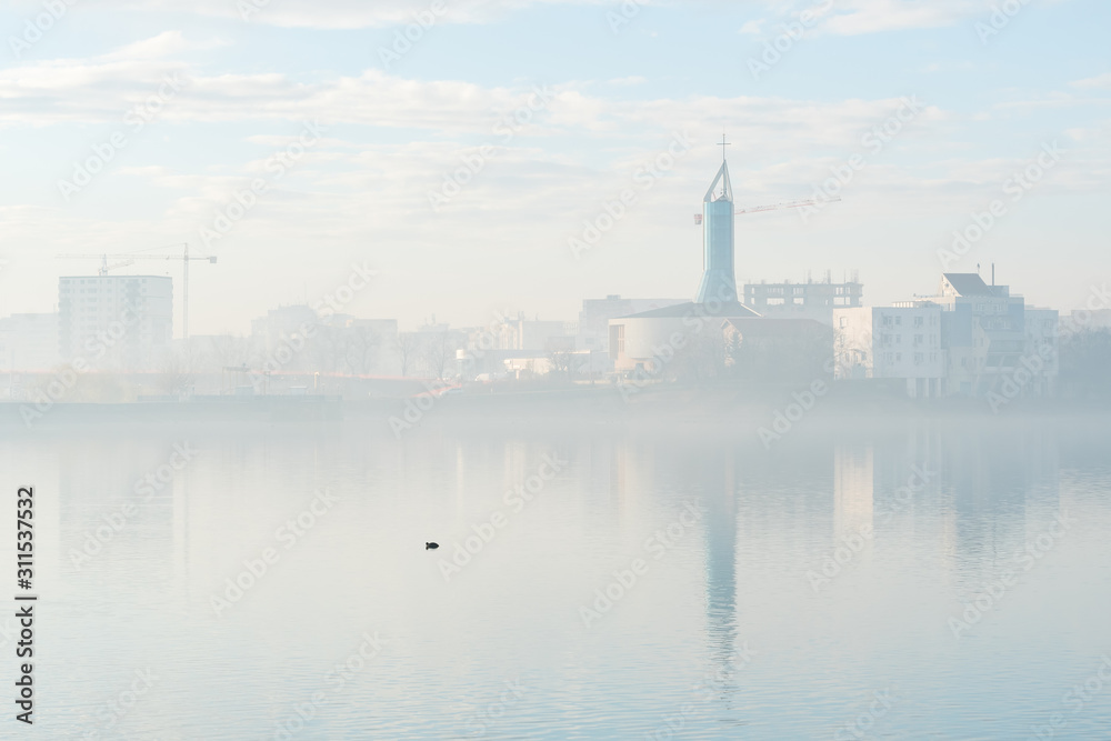 Beautiful City Reflections on the Lake Enveloped by Fog and Sunlight