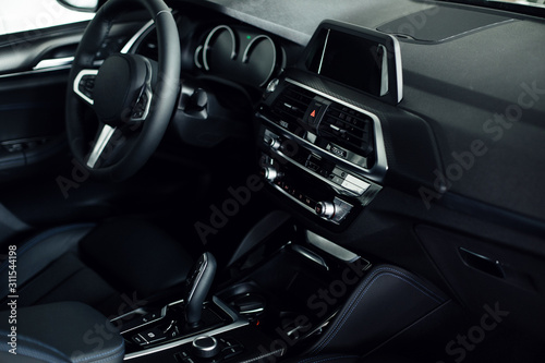 Business car interior. Interior of prestige modern car. Front seats with steering wheel, dashboard & display.  © VAKSMANV
