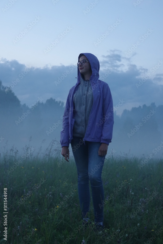 Girl in a blue jacket in a blue fog