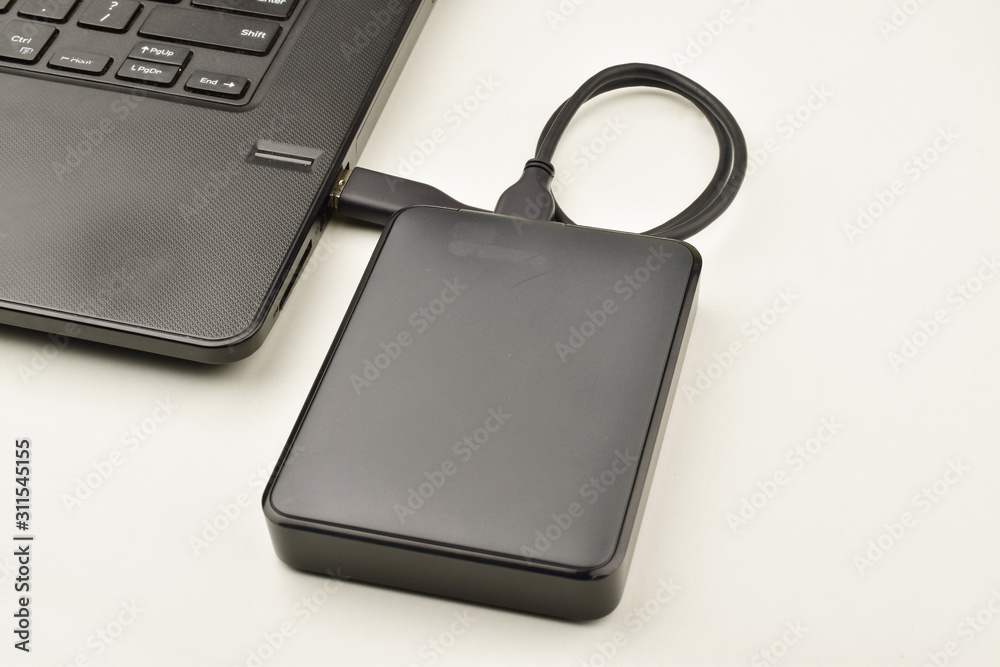 laptop connected to external hard disk over white background, data transfers concept laptop connected to external hard disk over white background, data transfers concept