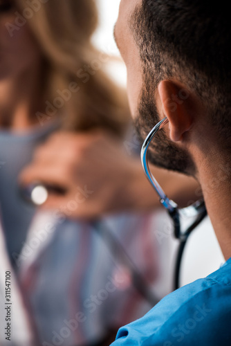 selective focus of doctor examining woman in hospital