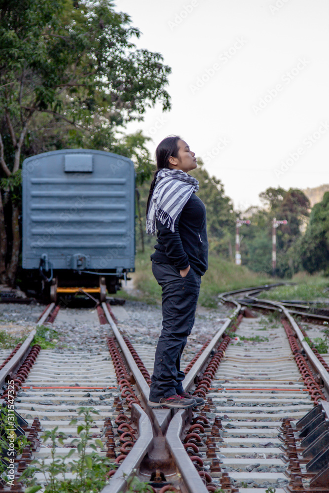 Solo traveller : Asian woman tourist is solo traveling and stand alone at railroad in train station. travel concept