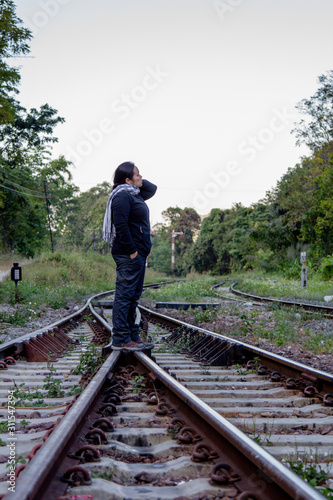 Solo traveller : Asian woman tourist is solo traveling and stand alone at railroad in train station. travel concept