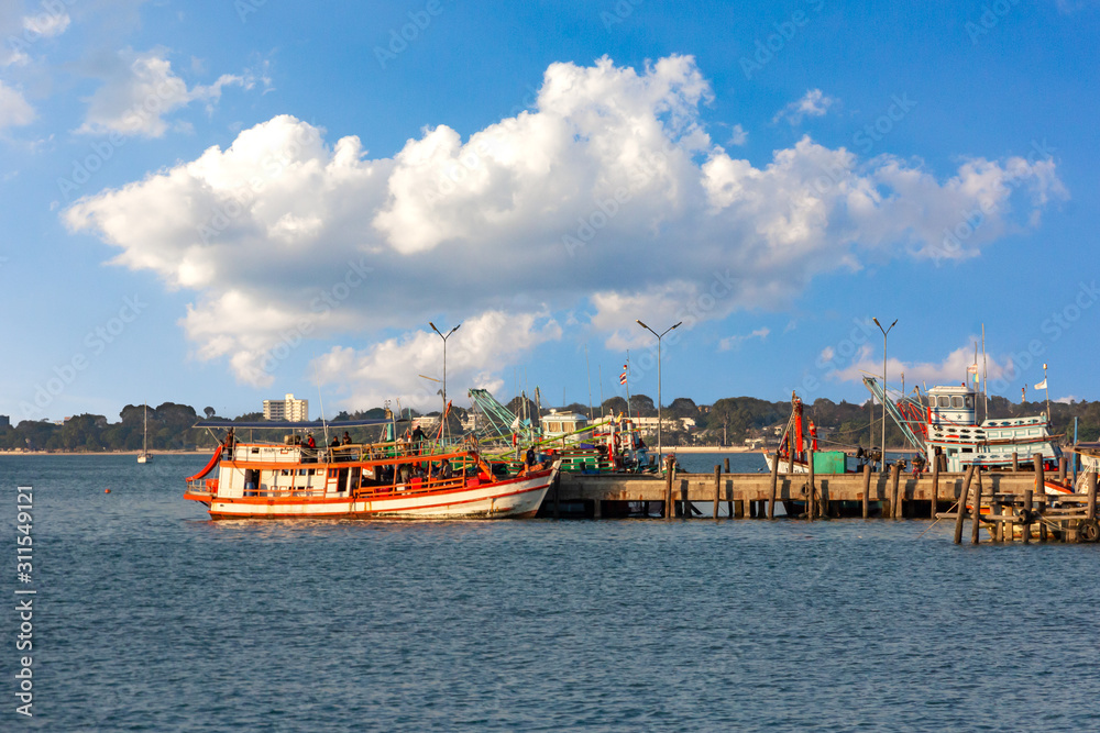 Fishing boats moored in Thailand with blue sky clouds