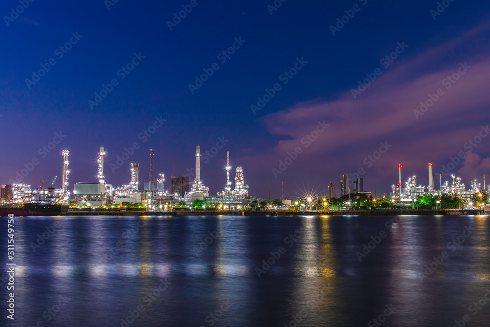 Oil refinery industry plant on blue sky at night at beside Chao Phraya river, Thailand. 