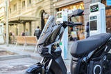 Electric motorbike charging in the city. Ecomobility concept.