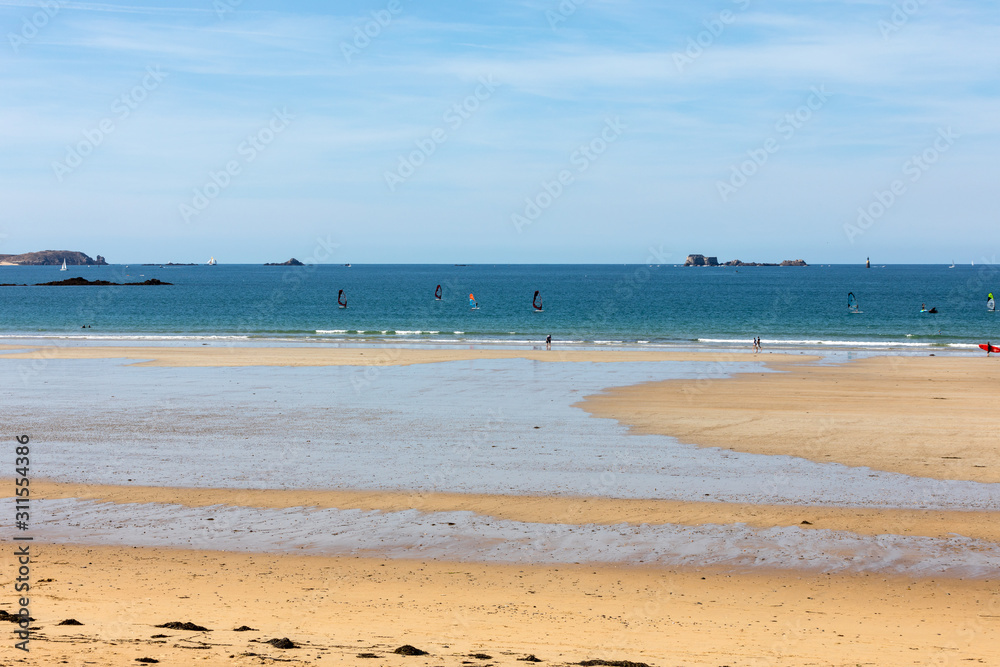 Windsurfers surfing along the beach in Saint Malo. Brittany, France