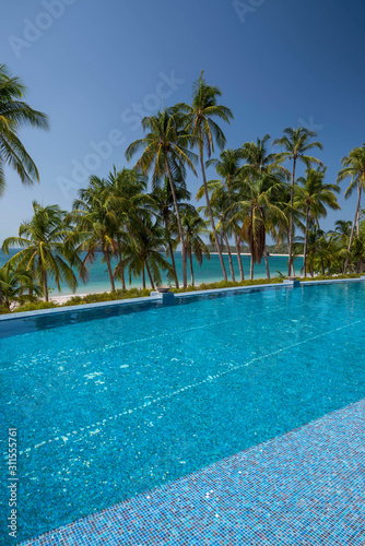 An infinity pool among palms on the beach over the Pacific Ocean, Las Perlas archipelago, Panamá, Central America
