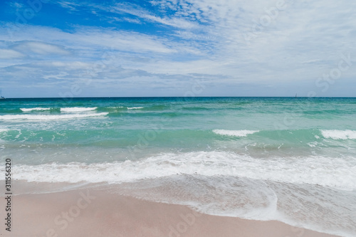 Ocean waves merging with blue cloudy sky