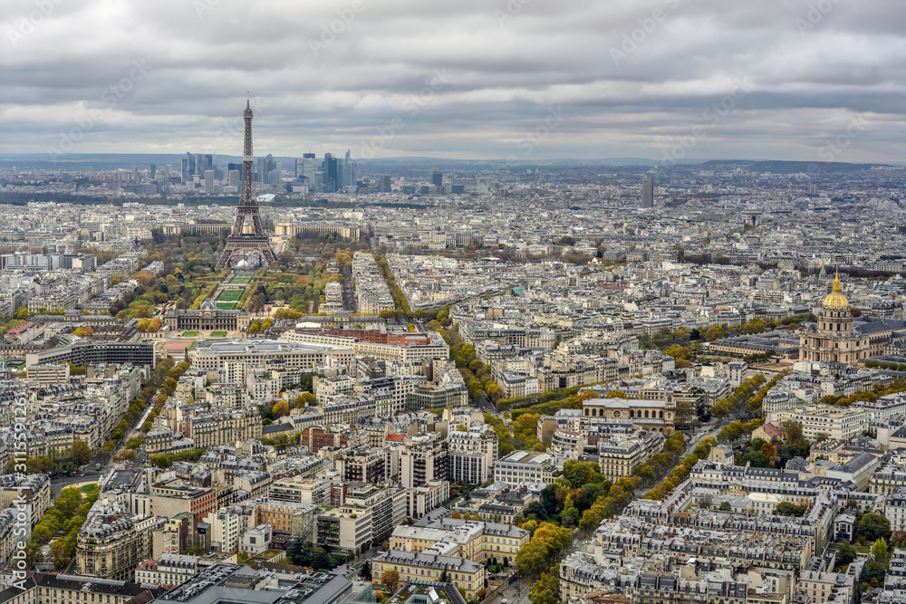 View of Paris from the height of a skyscraper. In the distance, the Eiffel Tower is visible, the house of the disabled is on the right