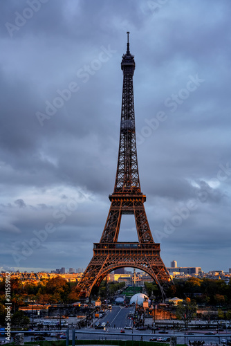 Eiffel Tower in cloudy weather in the rays of the setting sun