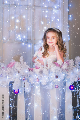 Nice girl in a white dress in Christmas decorations