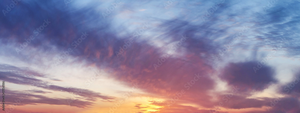 Sunset or sunrise sky panorama with sun and dramatic clouds