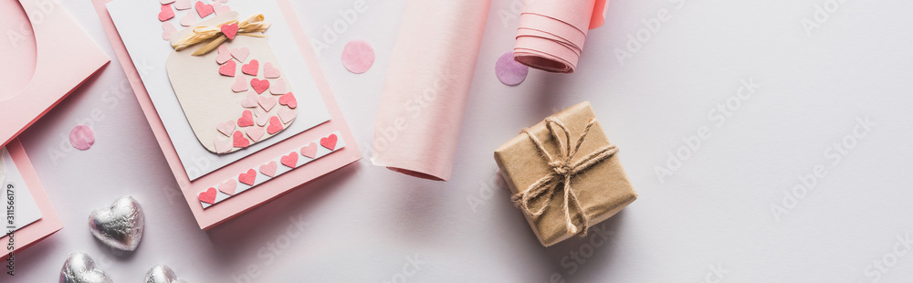 top view of valentines decoration, gifts, hearts and wrapping paper on white background, panoramic shot top view of valentines decoration, gifts, hearts and wrapping paper on white background, panoramic shot