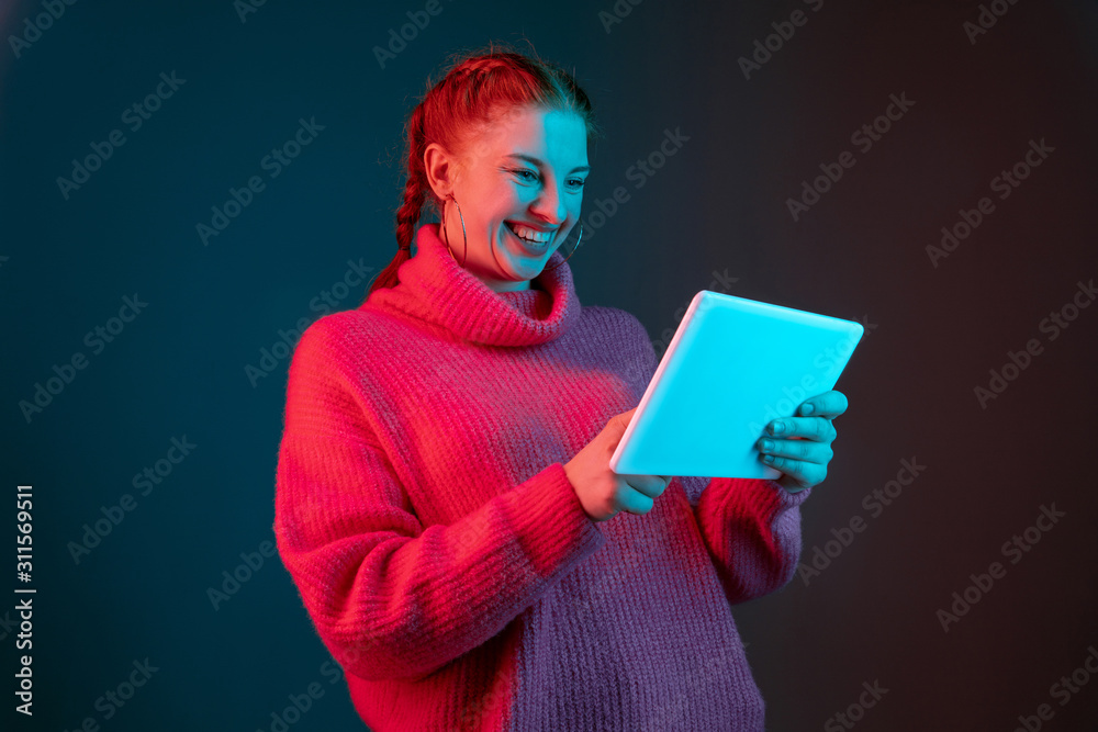 Using tablet, looks happy. Caucasian woman's portrait isolated on ...