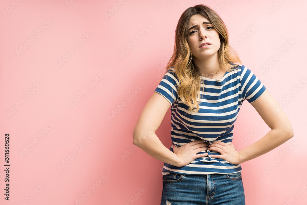 Female With Stomachache Against Colored Background Female With Stomachache Against Colored Background