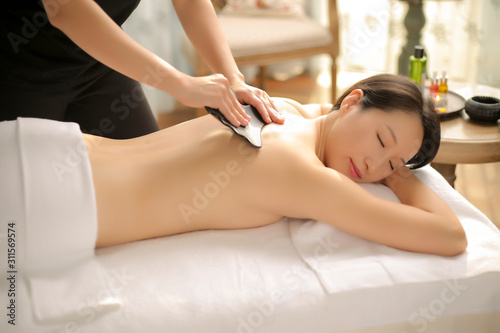 Masseur is massaging woman back in spa