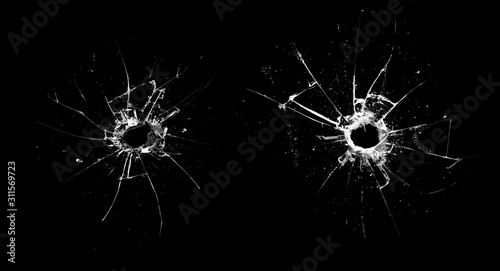 Vászonkép hole in the glass with cracks isolated on a black background