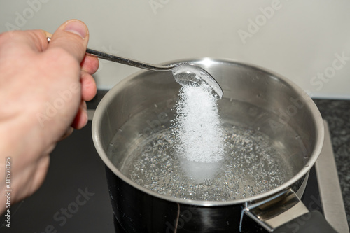Salz in das kochende wasser schütten