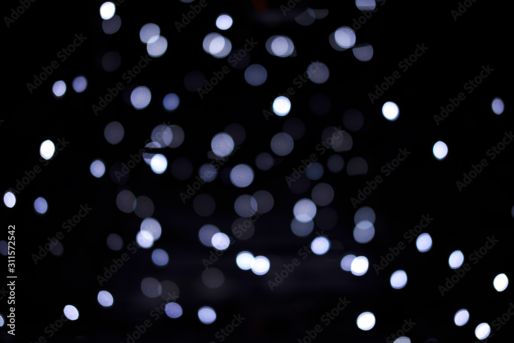 Silver and blue lights of the festive city on black background. Silver and blue lights of the festive city on black background.