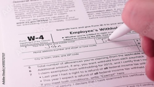 Tax reporting. Human fills out the W-4 tax form