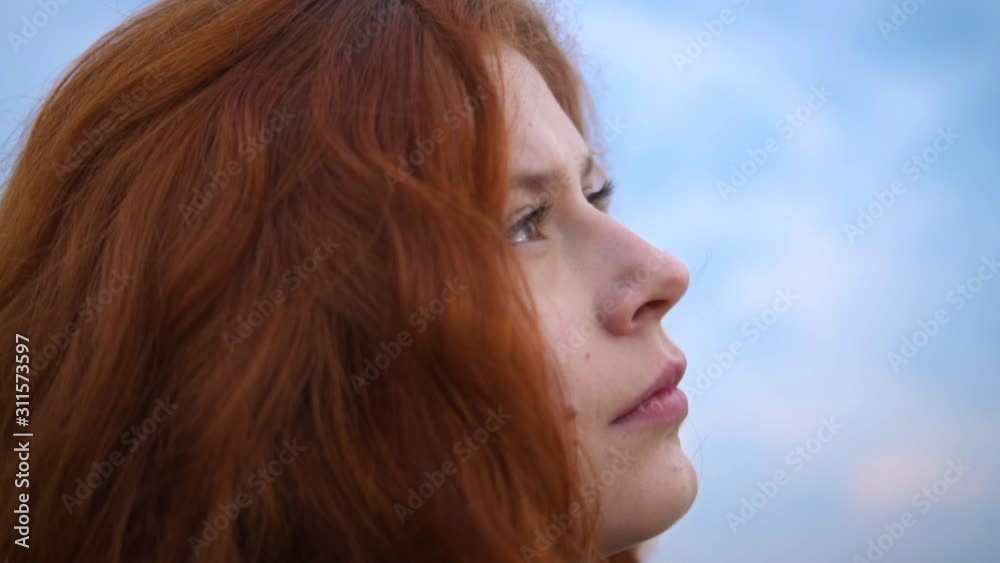 Сlose up Portrait of Beautiful Redhead Woman Looking up Mentally Praying with Wind Blowing Hair Сlose up Portrait of Beautiful Redhead Woman Looking up Mentally Praying with Wind Blowing Hair