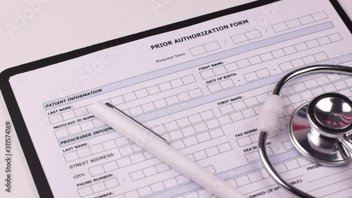 Prior authorization form, white pen and phonendoscope on a white background. Close-up