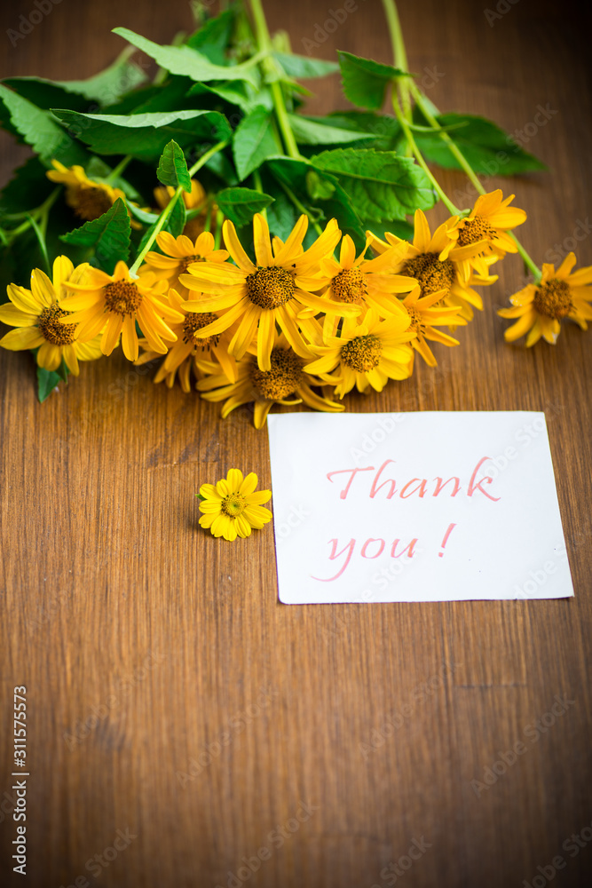 Naklejka premium bouquet of yellow big daisies on a wooden