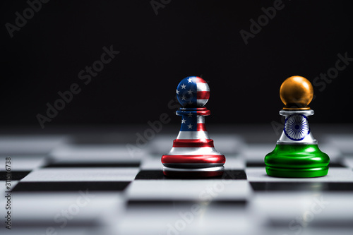 USA and India flag printed screen on pawn chess on board and black background. It is symbol of close relationships between both countries.