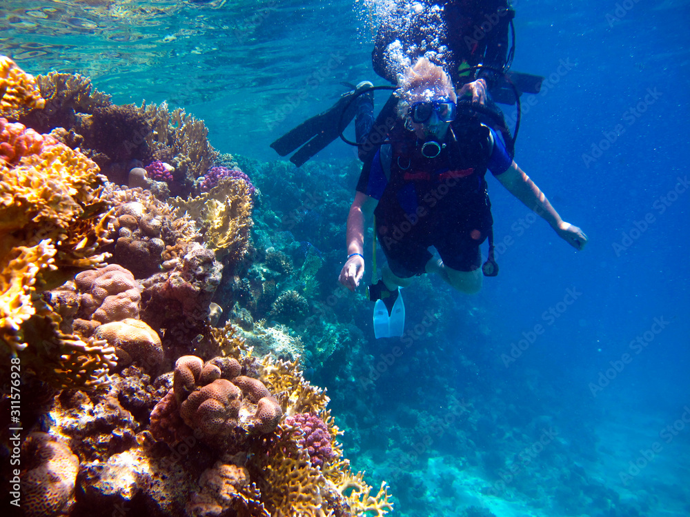 Woman scuba diver and beautiful colorful coral reef underwater