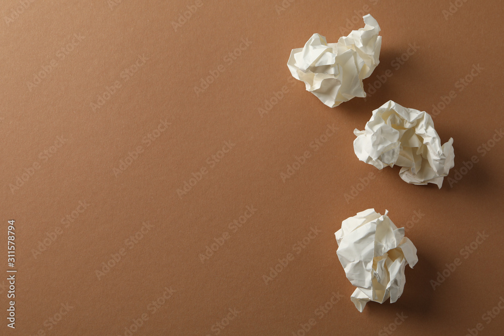 Paper balls on brown background, space for text Paper balls on brown background, space for text