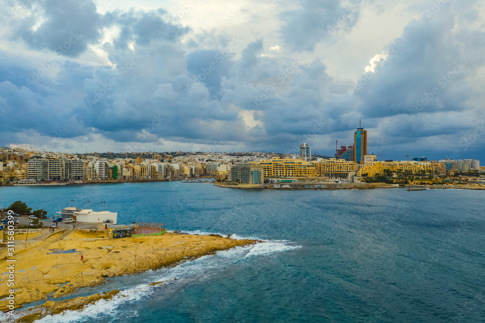 Aerial view of Saint Julian's city and Portomaso tower. Winter, sea, seafront, cloudy blue sky. Malta 