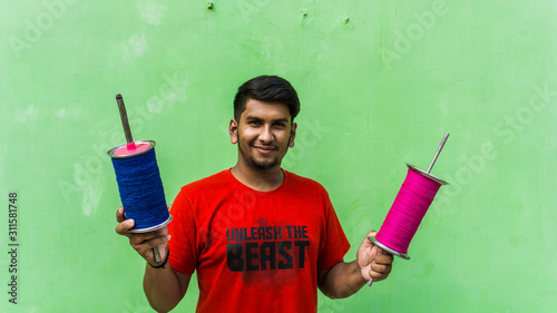 Young man with firki and pipuda for Makar Sankranti festival of India. Makar Sankranti is kite festival of India. It is also known as uttarayan photo