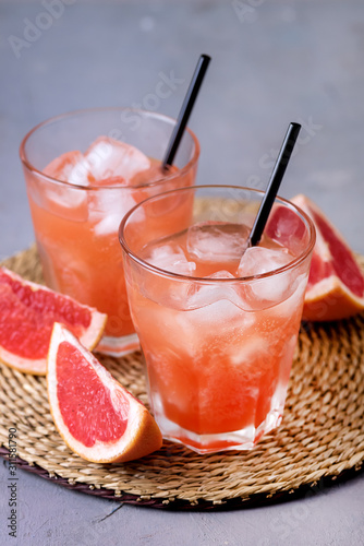 Two Glasses of Tasty Grapefruit Cold Drink or Cocktail Refreshment Beverage Gray Background Cold Grapefruit Juice Vertical
