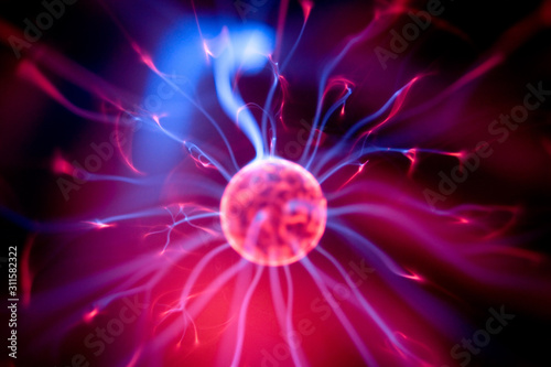 Decoration lamp in shape of plasma ball with red and blue electrodes, close-up