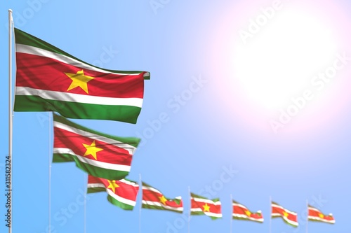 pretty anthem day flag 3d illustration. - many Suriname flags placed diagonal with bokeh and empty space for your text