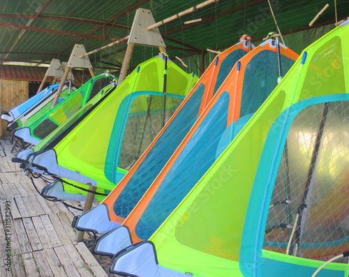 Different sails for windsurfing hanging on hangar, nautical center in Martinique. French West Indies.