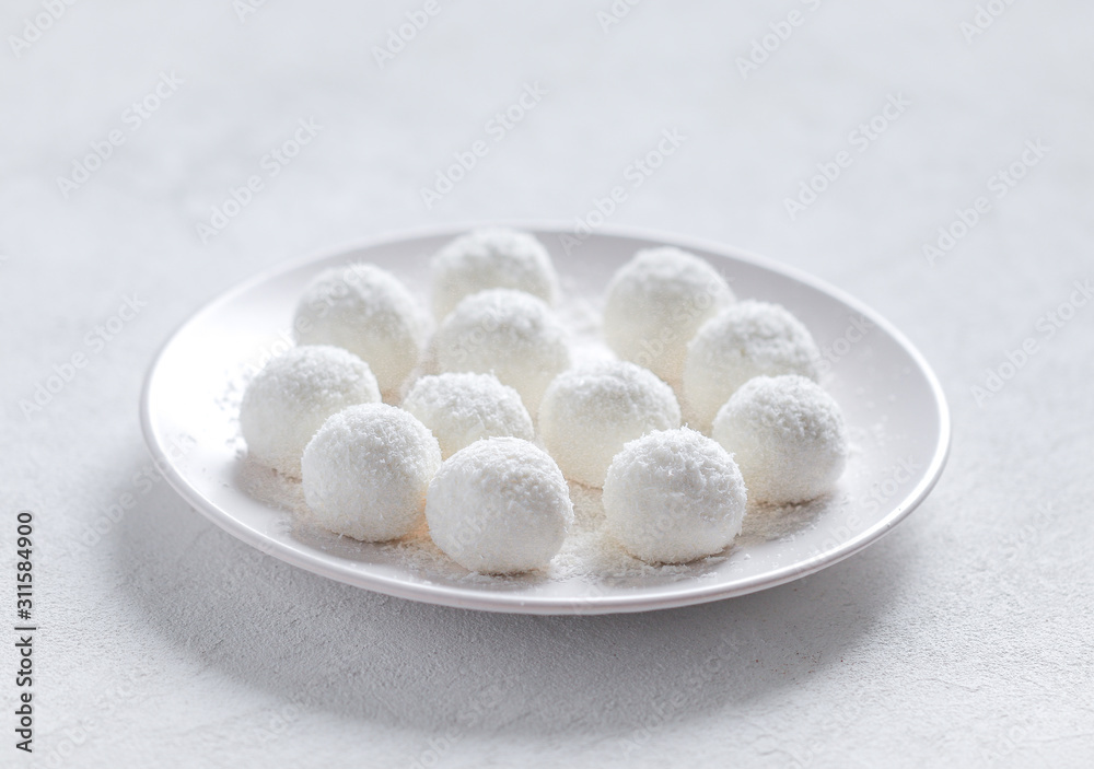 essert curd balls in coconut shavings on a light white background essert curd balls in coconut shavings on a light white background