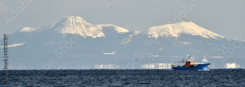 Japanese fishing vessels in the Sea of Okhotsk off the island of Kunashir. Winter season. photo