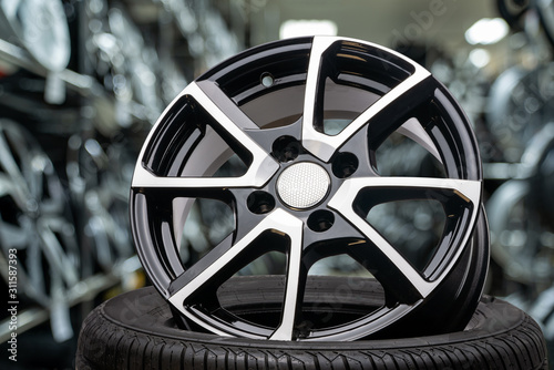 cast aluminum disc alloy wheel close up on background of tire shop inside