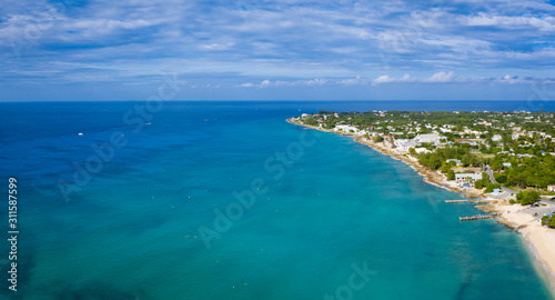 aerial drone footage of the island of grand cayman in the cayman islands in the clear blue and green tropical waters of the caribbean sea