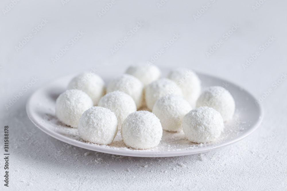 essert curd balls in coconut shavings on a light white background essert curd balls in coconut shavings on a light white background