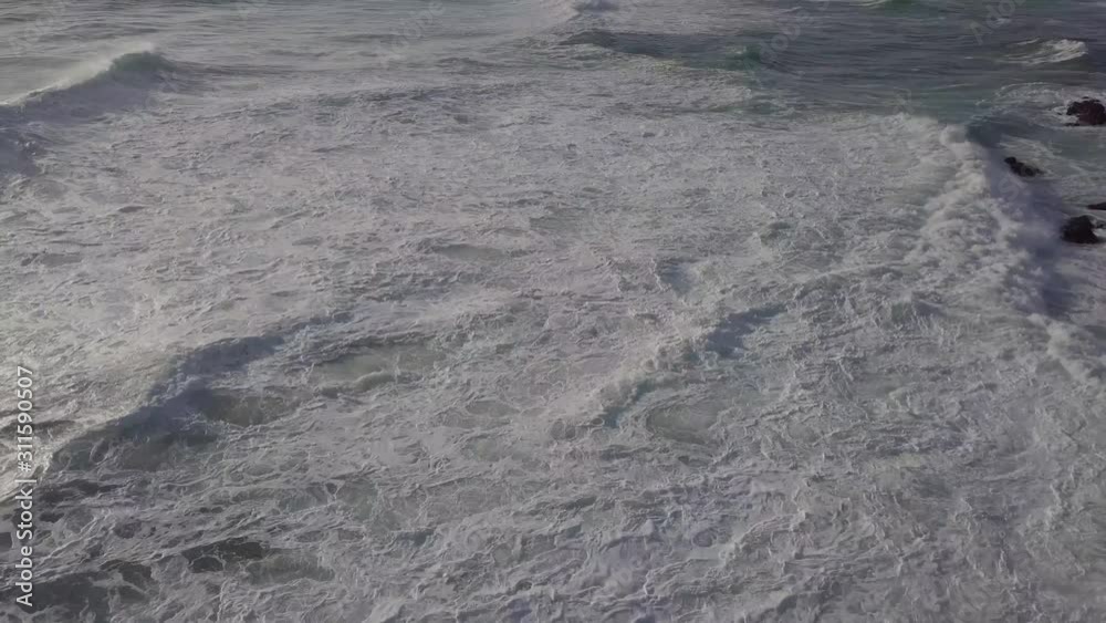 Incoming waves create chaos in the intertidal zone near shore, aerial Incoming waves create chaos in the intertidal zone near shore, aerial
